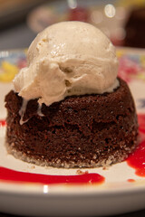 Chocolate lava cake with a scoop of vanilla ice cream and raspberry sauce