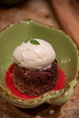 Chocolate lava cake with a scoop of vanilla ice cream and raspberry sauce and mint