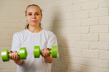 Woman Lifting Green Dumbbells During Home Workout