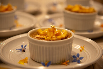 Mango crème brûlée dessert topped with edible gold