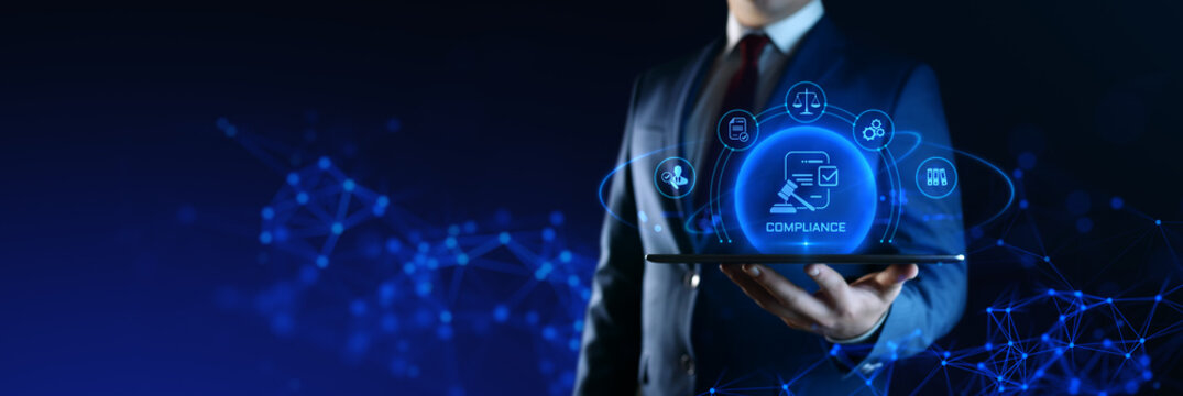 Businessman holding tablet with compliance icons on screen - business and regulations concept