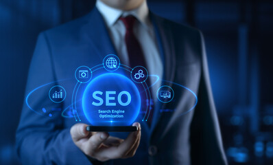 Businessman holding smartphone with Search Engine Optimization SEO icons on screen - Digital...