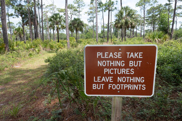Sign encouraging responsible use of outdoor spaces by taking only pictures and leaving only footprints