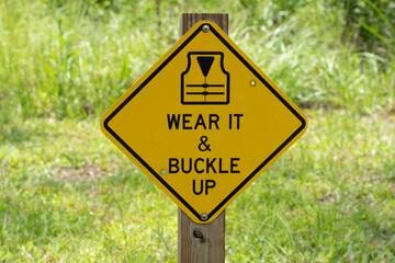 Sign encouraging the proper use of a life jacket while boating