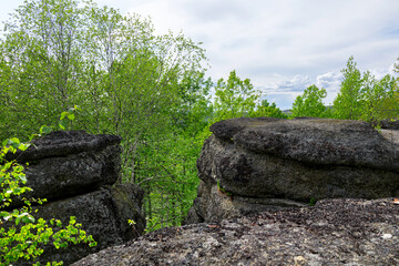 Huge rocks structures geological site in the place of ancient prehistoric ocean trench, nestled within a green forested environment. Rim rocks formation, Western Canada Sedimentary Basin, Alberta