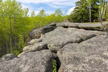 Huge rocks structures geological site in the place of ancient prehistoric ocean trench, nestled within a green forested environment. Rim rocks formation, Western Canada Sedimentary Basin, Alberta