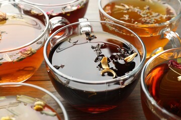 Aromatic herbal tea in glass cups on wooden table, closeup