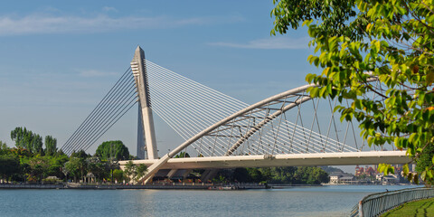 Seri Wawasan Bridge spans the water in Putrajaya, Malaysia. The modern design merges beautifully with the serene surroundings, offering a peaceful view for visitors