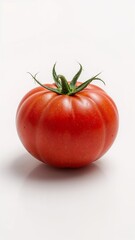Close up shot of a single red tomato with green stem on a white surface in a studio setting