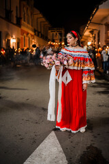 Mujer sahumadora vestida con traje típico tradicional participa en una procesión nocturna durante...