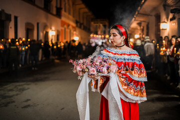 Mujer sahumadora vestida con traje típico tradicional participa en una procesión nocturna durante...