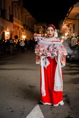Mujer sahumadora vestida con traje típico tradicional participa en una procesión nocturna durante...