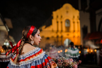 Mujer sahumadora vestida con traje típico tradicional participa en una procesión nocturna durante...