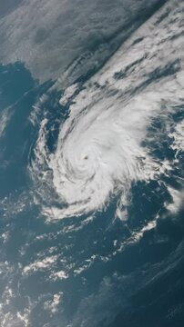 Aerial view of a powerful hurricane system with spiral rainbands over the dark blue ocean from space, a weather phenomenon.