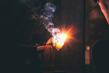 Fototapeta premium Mechanic Men hands use grinder Welding Hot flame metal work cutting fire iron workshop. Repairman Welder Locksmith use machine cut metal. Construction Worker hand Welding machinery iron metal grinder