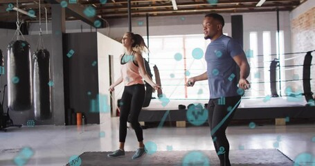Man and woman swinging ropes initiating skipping for fitness tracking with animated data icons - Powered by Adobe