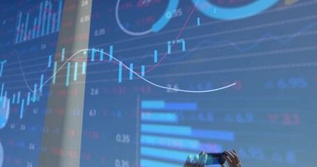 Engineer raising phone scanning wind turbine while energy candlesticks trend line pie chart merging - Powered by Adobe