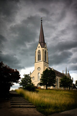 Church under a stormy sky. Church standing on a hill in Switzerland. Opposition of the storm sky and church