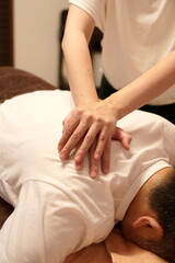 Japanese therapy using stacked palms to press shoulder blade