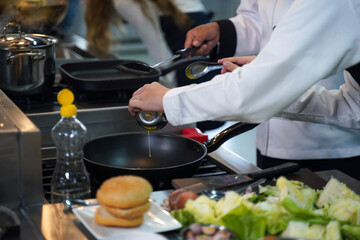 Close up.  Chef teacher teaches cooking to the group children in class kitchen room.  Chef preparing student for learning marking and cooking food at workshop.  Education Concept
