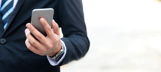 Close up hand businessman using smart phone to work with financial data in city. Business Concept
