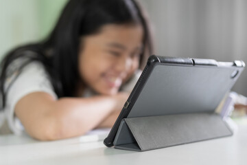 closeup tablet and smartphone with blur asian child or kid girl fun study online class or learn from home school by computer and mobile phone with smile or people studying learning by technology