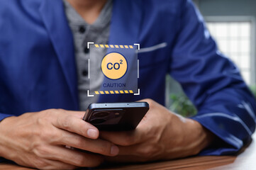 Person Holding Smartphone with CO2 Caution Notification Displayed