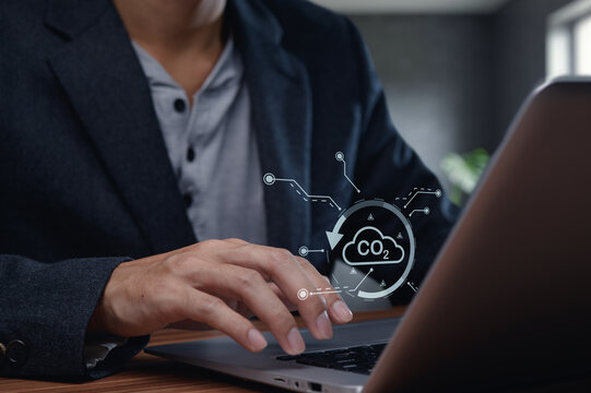 Hand on Laptop Keyboard with CO2 Concept and Digital Overlay