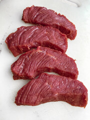 Thick cut of red beef meat on white