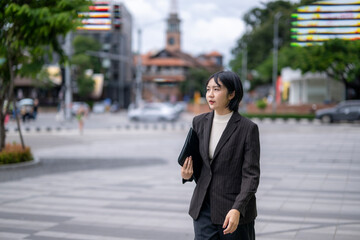 A woman in a business suit is walking down a city street