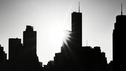 City skyline silhouette against a bright sun backdrop