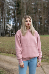 Portrait of young beautiful blonde girl with Doberman outdoors.