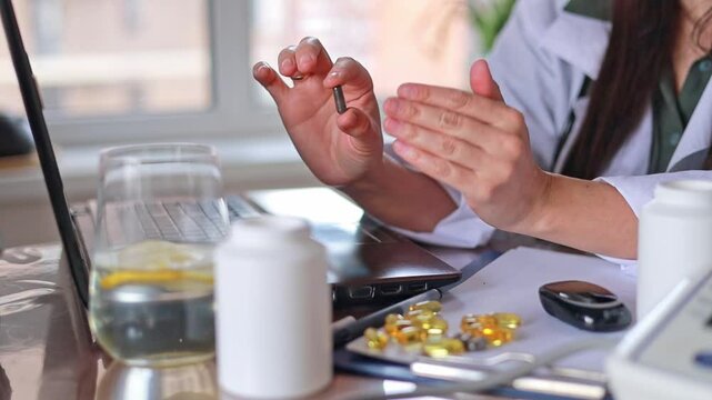 Close-up Doctor shows dark oval capsules and pills. Alternative medicine, Dietary supplements, Vitamins and minerals