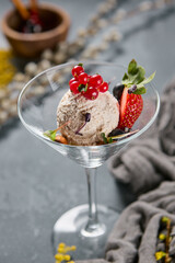 Vegan berry ice cream in frosted moody lighting, elegant minimal composition, garnished with fresh red currant and strawberry