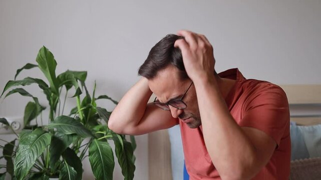 Man touches back of head and head due to headache and feeling unwell