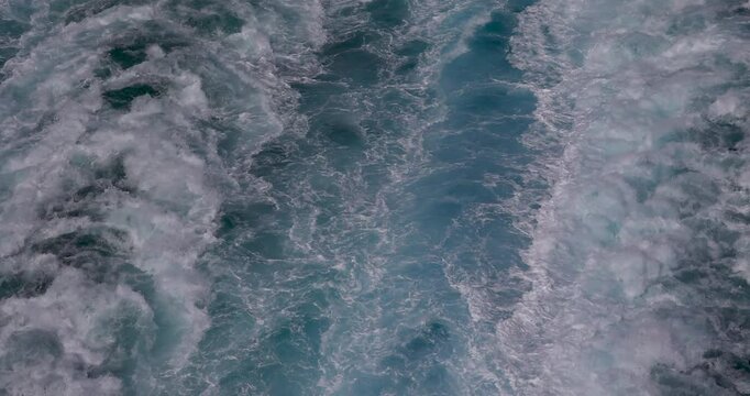 Pacific ocean wake behind cruise ship 4K. Destination vacation travel tropical ocean sea. Caribbean cruise. Beautiful blue Ocean water. Powerful propeller wash and fluid dynamic cause a pattern.
