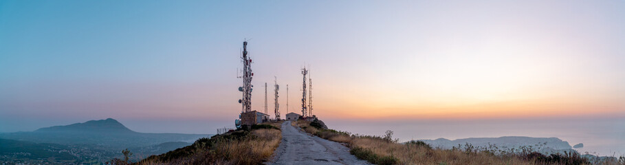 Obraz premium Telecommunication antennas in the mountain at sunrise. In Cumbres del Sol, Benitachell, Comunidad Valenciana (Spain)