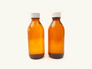 Amber glass bottles with an aluminum cap isolated on a white background, 2 brown glass bottles for pharmaceuticals, syrups, essential oils, and cosmetics
