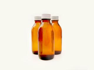 Amber glass bottles with an aluminum cap isolated on a white background, 3 brown glass bottles for pharmaceuticals, syrups, essential oils, and cosmetics