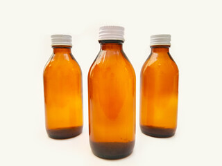 Amber glass bottles with an aluminum cap isolated on a white background, 3 brown glass bottles for pharmaceuticals, syrups, essential oils, and cosmetics