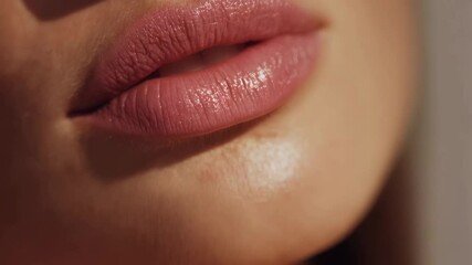 Close-up view of perfectly shaped lips during a beauty tutorial showcasing application techniques for natural makeup in a bright, studio setting