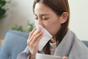 Flu and common cold in winter season concept, Woman sneezing on the bad and have fever resting at...