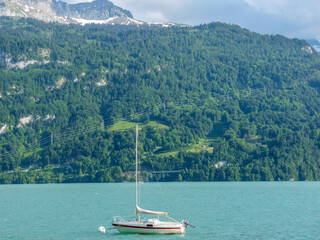 Switzerland, Meiringen, a small boat in a body of water with a mountain in the background