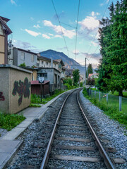 Switzerland, Meiringen, a train track traveling down train tracks near a building