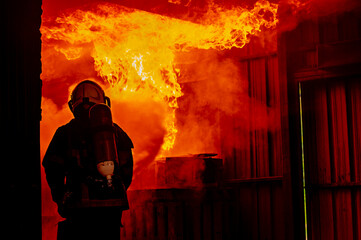 firefighters wearing fire fighter suit for safety and using twirl water extinguisher for fighting the fire flame in emergency situation.. - Safety Firefighter and industrial concept.