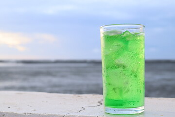 Green soft drink and ice cubes