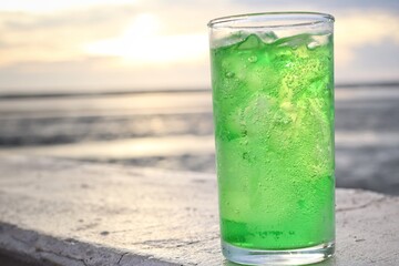 Green soft drink and ice cubes