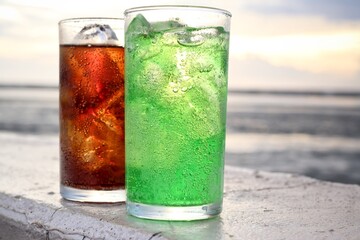 Green and cola soft drink and ice cubes