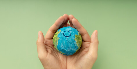 Happy Earth in hands symbolizing sustainability, global happiness, environmental care, and ecological responsibility, Top View