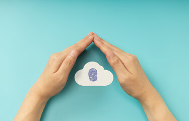 Hands shielding Fingerprint on Cloud symbol, representing Cybersecurity, data privacy, and online protection. Top View
